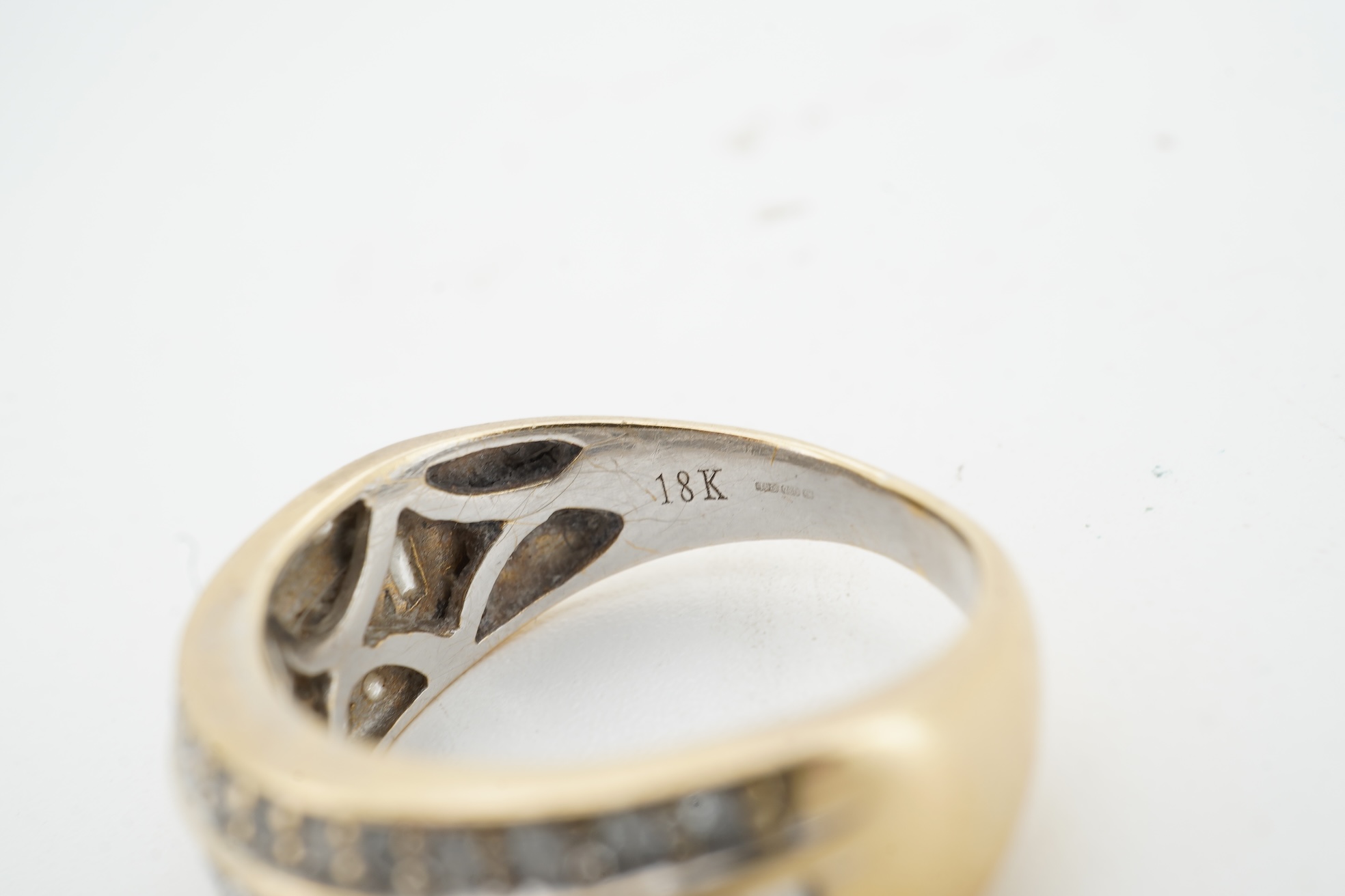 A diamond ring, the wide band set with a line of alternating brilliant-cut and baguette diamonds, between bands of brilliant-cut diamonds, mounted in gold, size M, British hallmarks for 18ct gold, total diamond weight ap